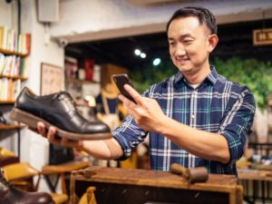 Best Low Cost Marketing Ideas for Small Businesses - Photo of a cobbler taking photo of shoe that he has repaired