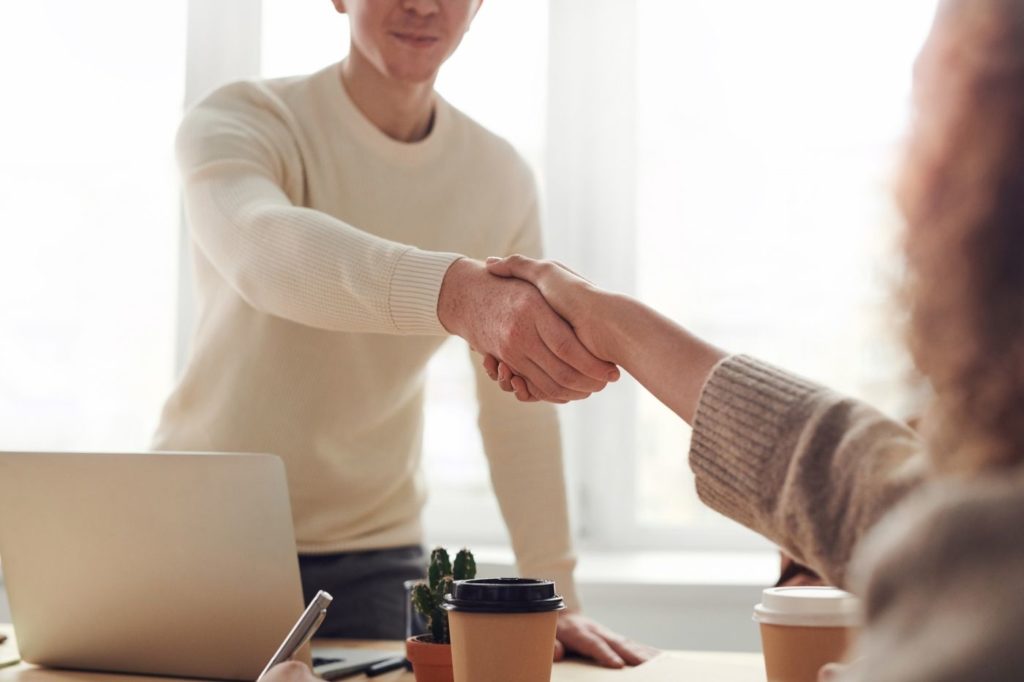 How to Find a Good Marketing Specialist - two people shaking hands over a desk