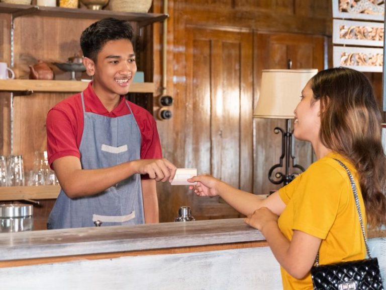 Develop a customer journey messaging template - photo of cafe staff handing credit card back to customer