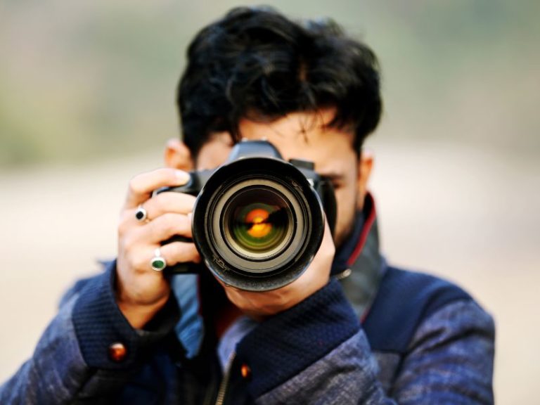 content bank - photo of a photograher pointing their camera ready to take a photo