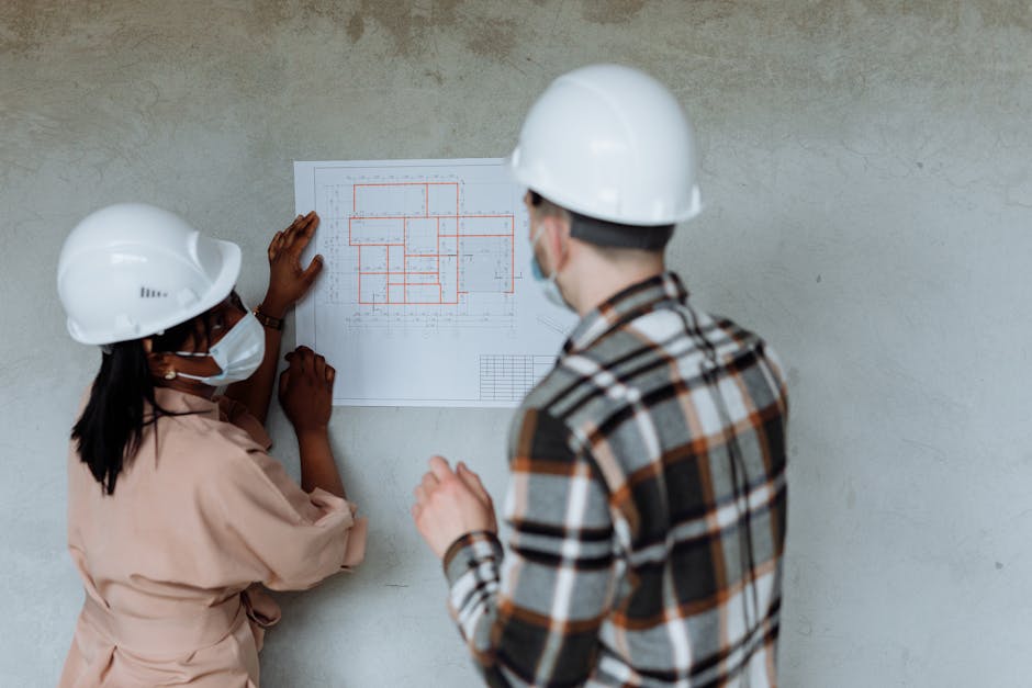 Engineers reviewing blueprints together on a construction site