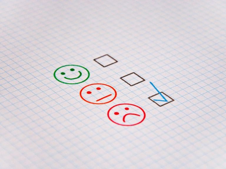online reputation increasing customer reviews in 2022 - photo of paper with happy, neutral and sad faces next to tick boxes