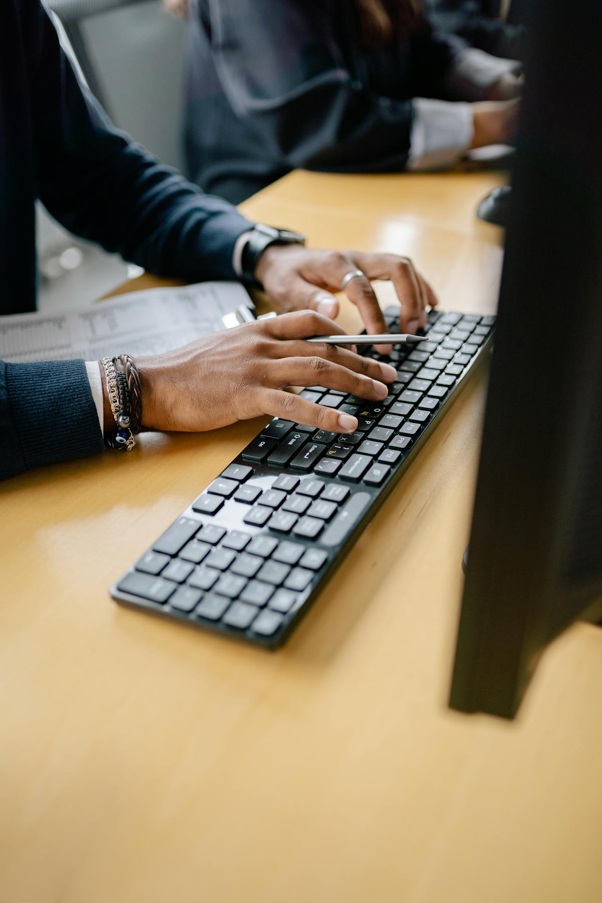 Close-up of hands typing on keyboard in an office