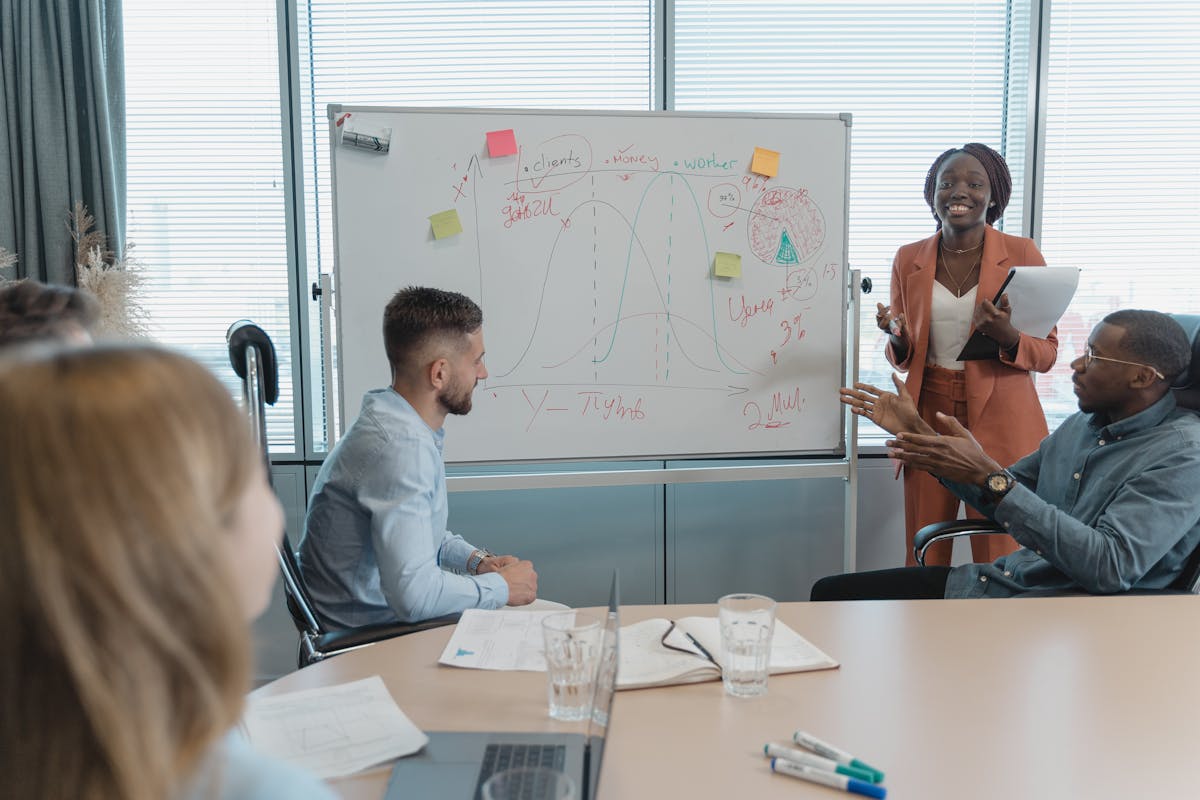 Multicultural team discussing strategies in a conference room with whiteboard